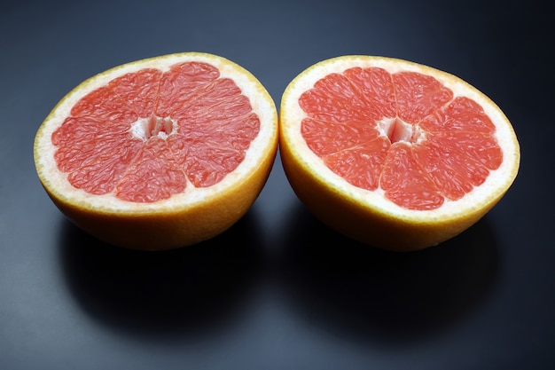 Grapefruit auf dunklem Hintergrund schneiden