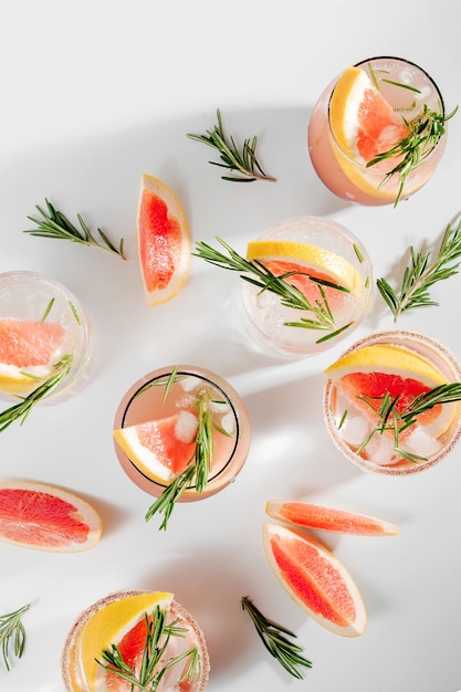 Grapefruit-Gurken-Gin-Cocktail auf eleganten Gläsern auf weißem Hintergrund