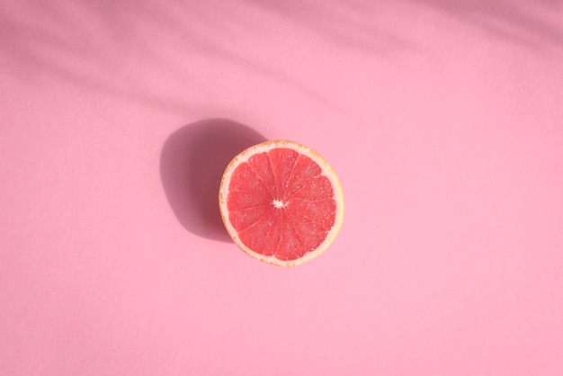 Grapefruit halbiert auf rosa Hintergrund