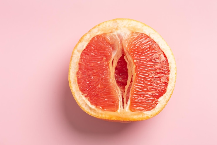 Foto grapefruit minimal abstraktes konzept eine halbe saftige grapefruit hautnah auf einem rosa hintergrund