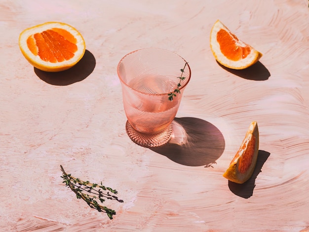 Grapefruitsaft und Grapefruit auf rosa Hintergrund
