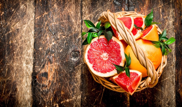 Grapefruitscheiben in einem Korb. Auf einem Holztisch.