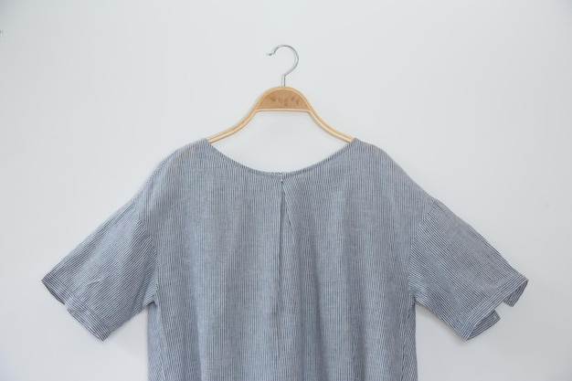 Foto graue bluse ist kleiderhänger auf weißem hintergrund