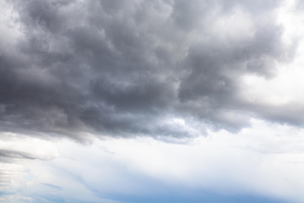 Graue Regenwolken am blauen Himmel am Sommertag