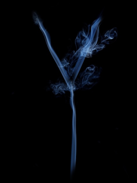 Grauer Buchstabe Y aus Rauch auf schwarzem Hintergrund