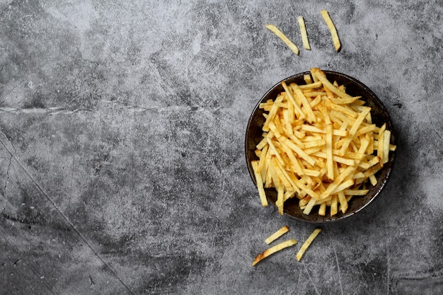 grauer Hintergrund mit Schüssel Pommes Frites Stick