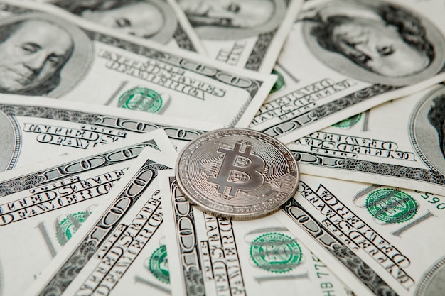 Graues Bitcoin auf US-Dollar-Scheinen. Konzept des elektronischen Geldwechsels
