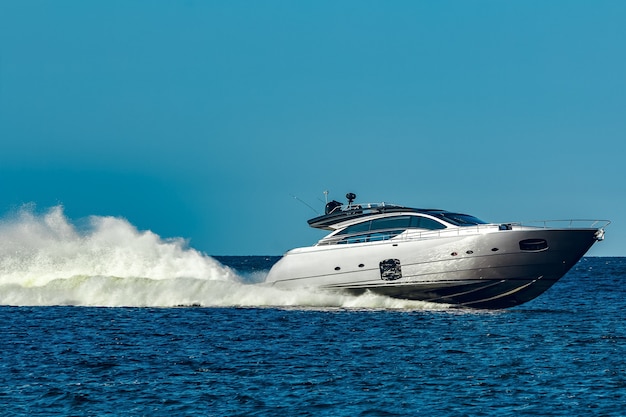 Graues schnellboot, das sich schnell durch den fluss in lettland bewegt. wassersport