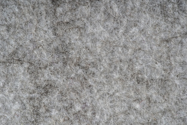 Graumelierter Strickstoff aus synthetischen Fasern mit strukturiertem Hintergrund. Graue gestrickte Stoffbeschaffenheit. Hintergrund mit zartem Streifenmuster, Nahaufnahme