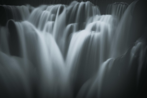 Graustufen-Nahaufnahme der schäumenden Kaskaden eines Wasserfalls