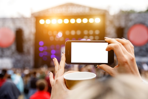 Foto gravação de concerto de música ao ar livre em um telefone celular. tela em branco