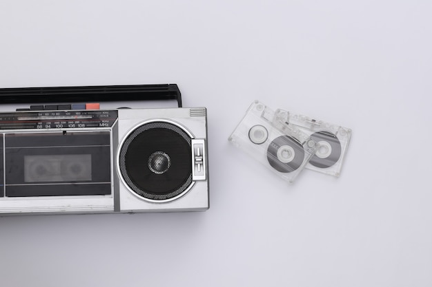 Foto gravador de fita cassete de rádio estéreo portátil retro desatualizado retro dos anos 80 e fita cassete de áudio em fundo branco. vista do topo. postura plana