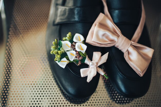 Gravata borboleta, flor na lapela e sapatos