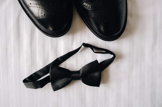 Gravata preta clássica e botas pretas na superfície