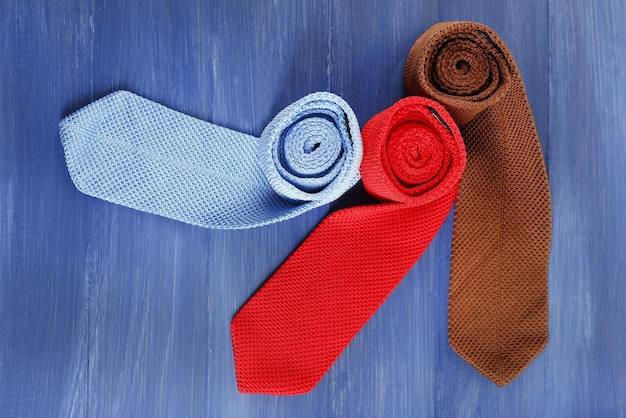 Gravatas masculinas coloridas na cor de fundo da mesa de madeira