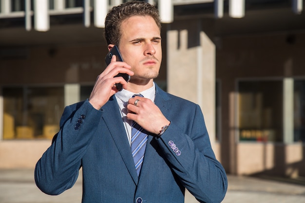 Grave jovem empresário falando no telefone.