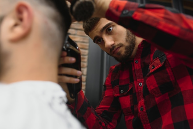 Grave joven barbudo corte de pelo por peluquero. Tema de barbería