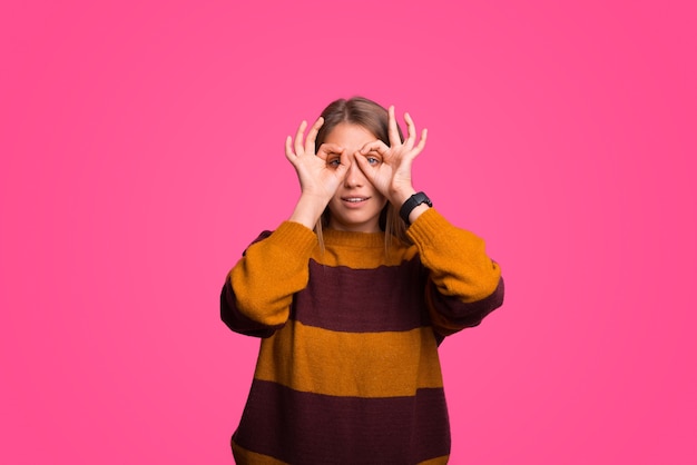 Grave joven está mirando a través de sus binoculares con los dedos.