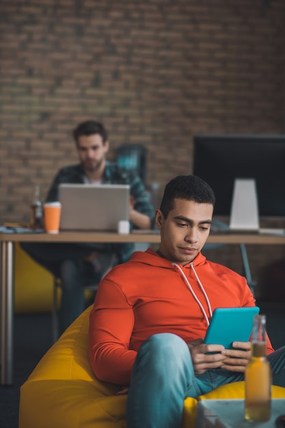 Grave joven mirando la pantalla de su tableta mientras navega por Internet