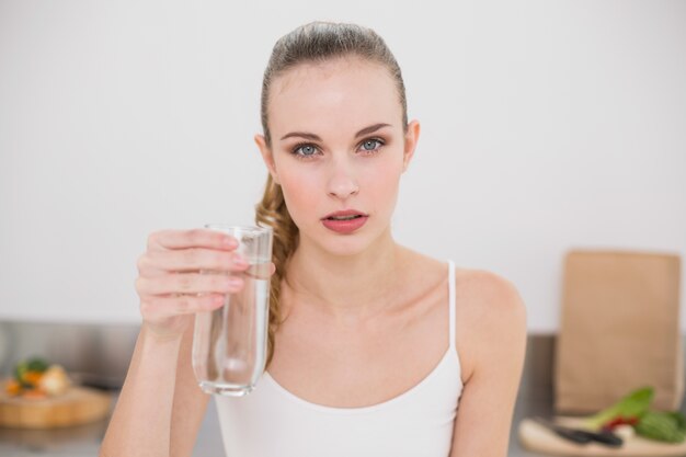 Grave joven sosteniendo un vaso de agua