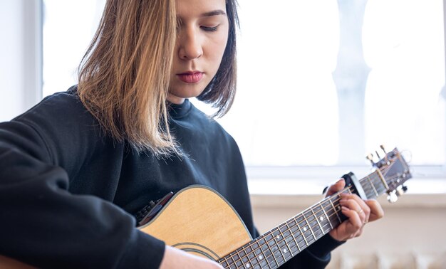 Grave joven tocando la guitarra acústica copia espacio