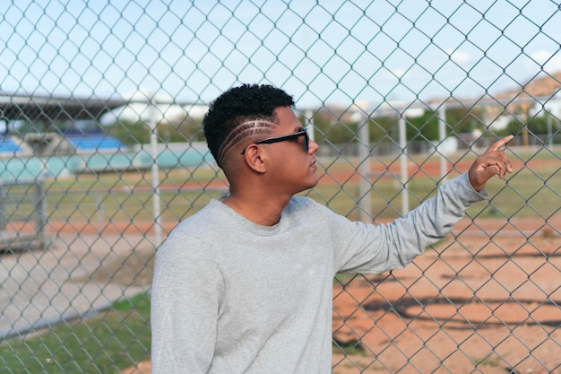 Grave joven en una valla con gafas de sol