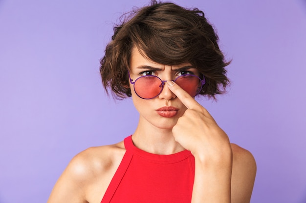 Grave mujer bonita morena corrige sus gafas de sol