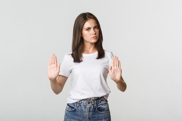 Grave mujer joven disgustada mostrando gesto de parada, diciendo que no.