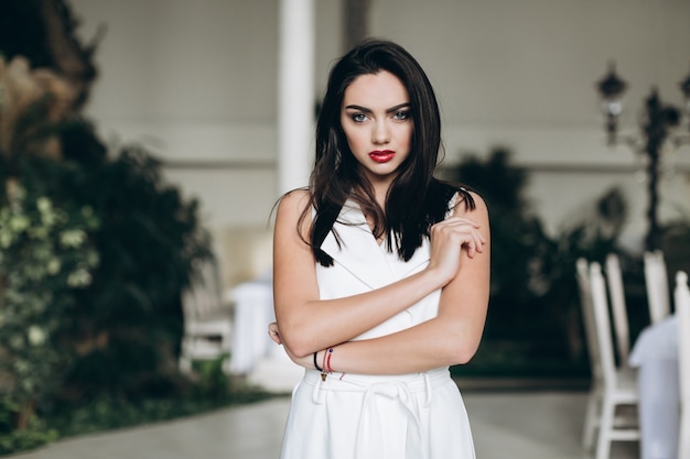 Grave mujer joven en vestido blanco