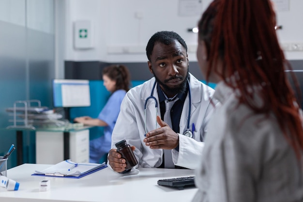 Grávida adulta recebendo frasco de pílulas do médico