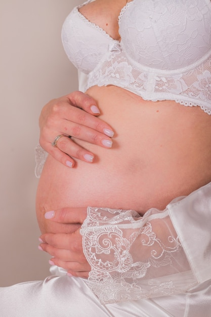Grávida barriga nua linda noiva vestindo lingerie sexy. mulher grávida em lingerie branca. belo conceito de gravidez.