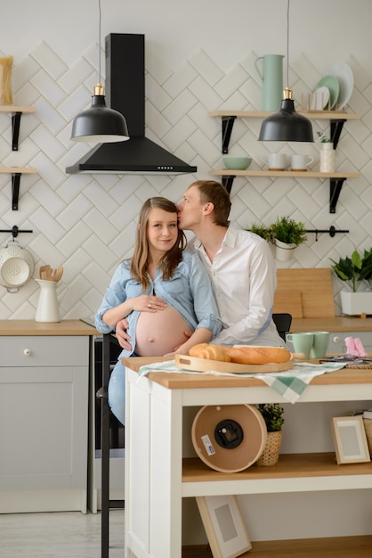 Grávida casal apaixonado sentado na cozinha