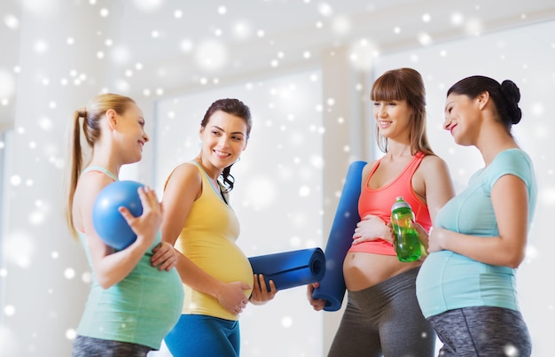 gravidez, desporto, fitness, pessoas e conceito de estilo de vida saudável - grupo de mulheres grávidas felizes com equipamentos desportivos a falar no ginásio sobre a neve