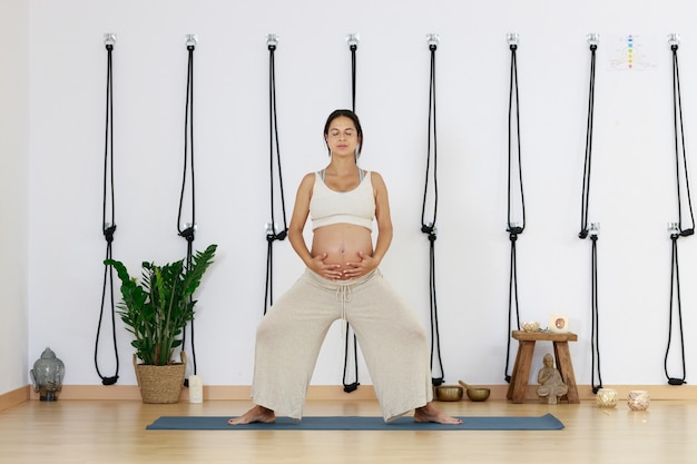 Gravidez Yoga Jovem praticando Yoga em casa