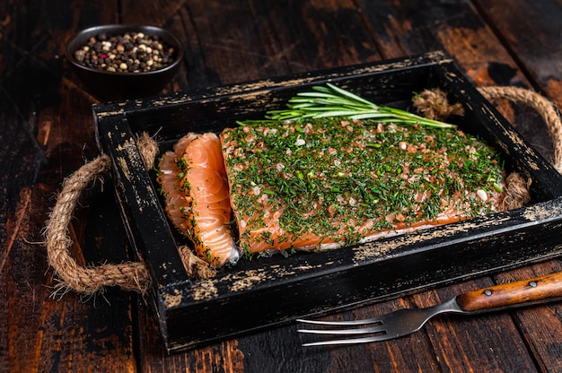 Gravlax de salmão curado com endro e sal em bandeja de madeira