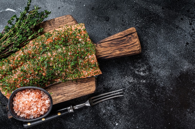 Gravlax Lachs mit Dill und Salz auf Holzbrett