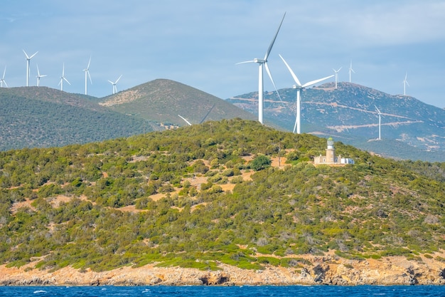 Grecia. Costa montañosa del Golfo de Corinto en tiempo soleado. Muchos parques eólicos y antiguo edificio del faro.