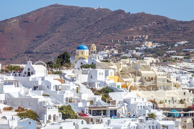 Grécia. Dia ensolarado de verão na ilha de Santorini. Edifícios brancos e a montanha ao fundo