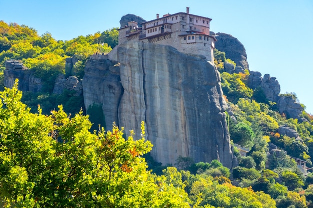 Grecia Día soleado de verano en Meteora El monasterio en la cima de la roca contra el telón de fondo de la ladera verde de la montaña