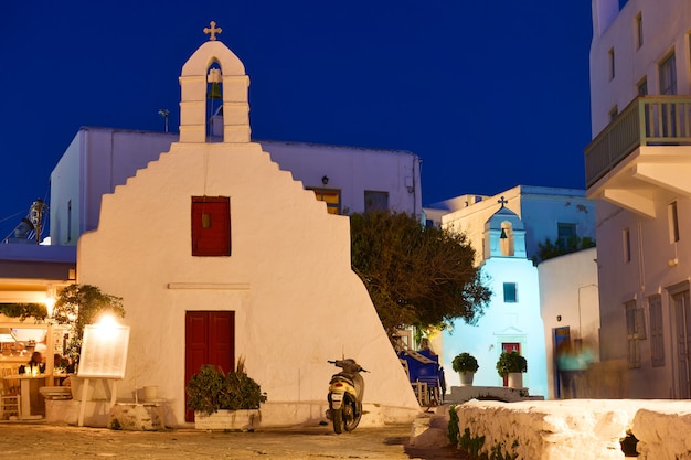 Grecia, isla de Mykonos. Plaza con iglesia antigua en la ciudad de Chora por la noche. Arquitectura griega, paisaje urbano