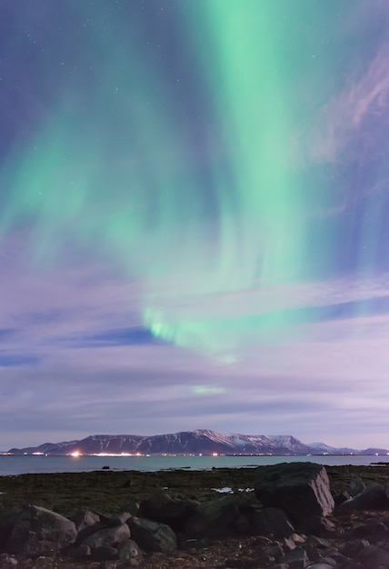 Green Aurora Borealis über einen schwarzen Sandstrand