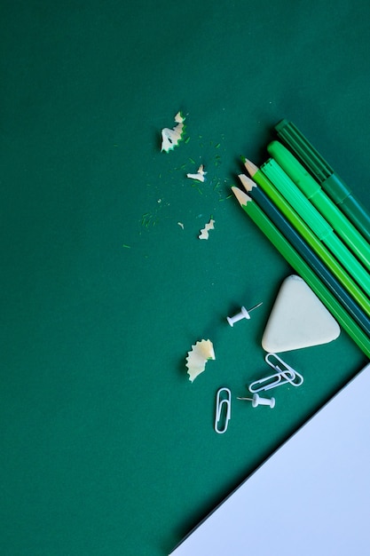 Green Flat lay volta ao conceito de escola, escola e material de escritório com espaço de cópia. Muitos itens de papelaria diferentes em fundo colorido