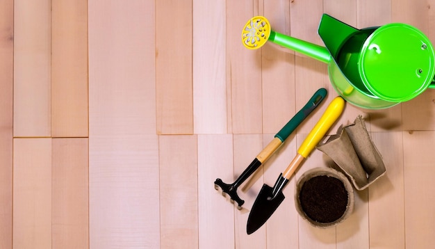 Green Thumb Essentials Draufsicht auf Gartengeräte auf dem Holzboden. Machen Sie sich bereit für die Kultivierung