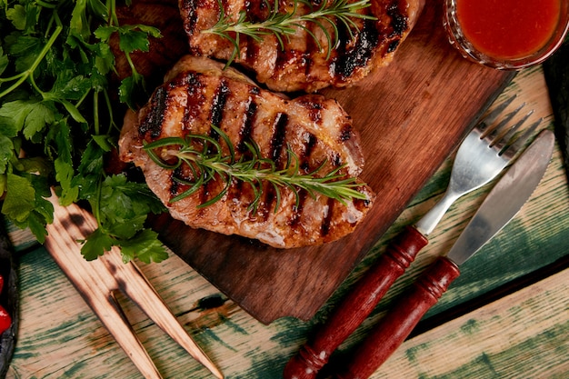 Grelha de carne de porco bife na tábua de madeira