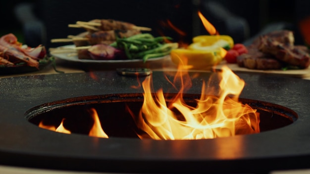 Grelha ficando quente para cozinhar alimentos fora Chamas de fogo queimando na churrasqueira