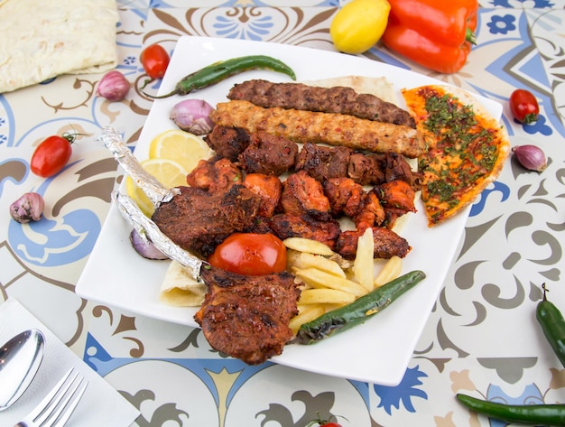 Grelhas misturadas com tikka boti seekh kabab de frango, carne bovina, cordeiro, carneiro, prato de churrasco servido em prato isolado na mesa, vista da comida árabe