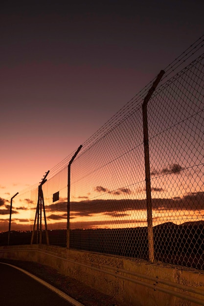 Grenzzaun bei Sonnenuntergang. Grenze zwischen den Ländern.