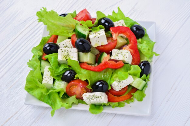 Griechischer Salat auf einem weißen Holztisch