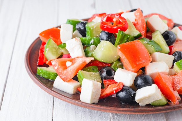 Griechischer Salat auf hölzernem Hintergrund.