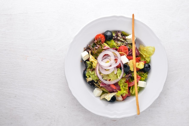 Griechischer Salat Frisches Gemüse auf einem hölzernen Hintergrund Ansicht von oben Freier Platz für Text